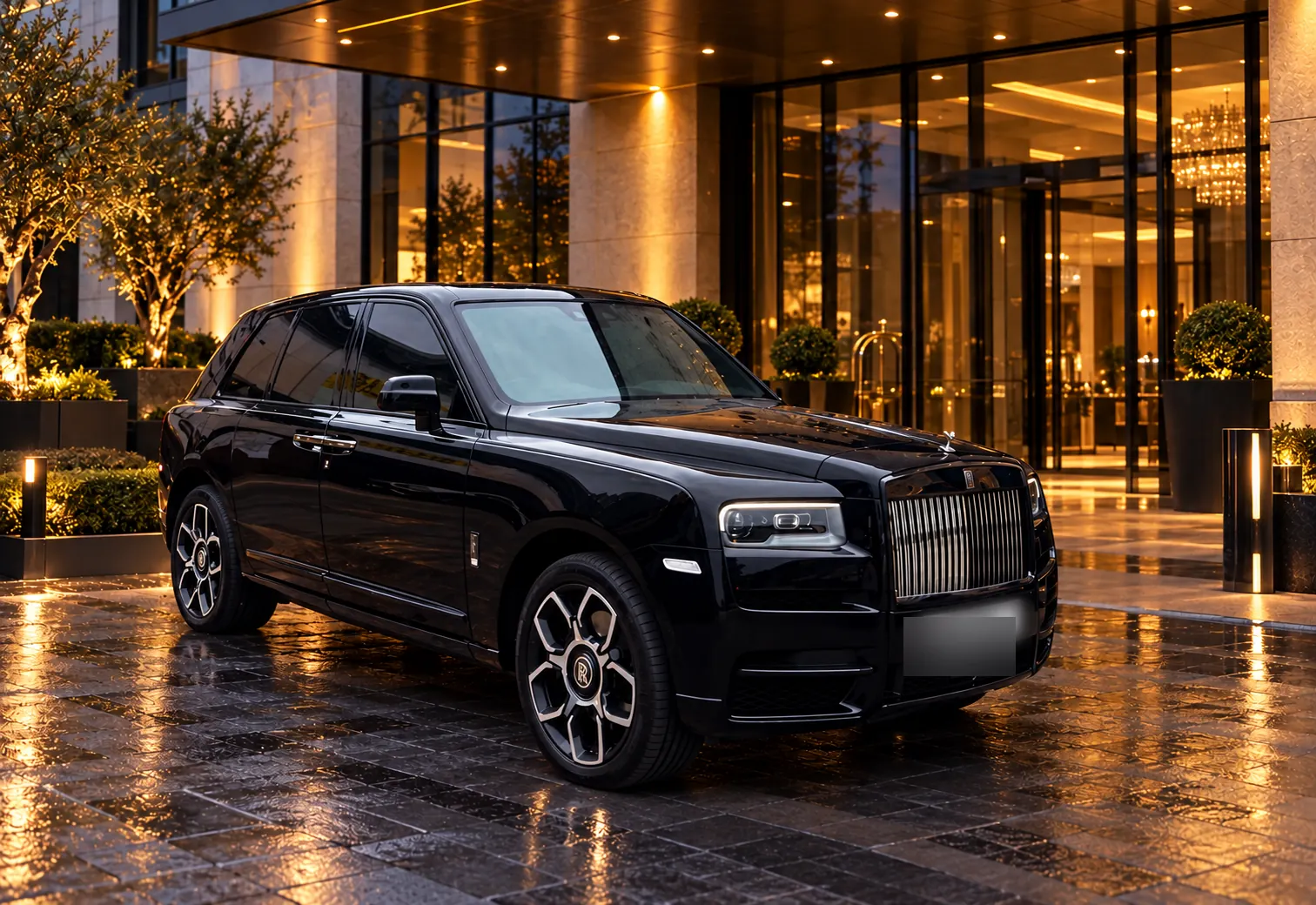 Black Rolls-Royce Cullinan chauffeur car parked outside a luxury hotel entrance at dusk